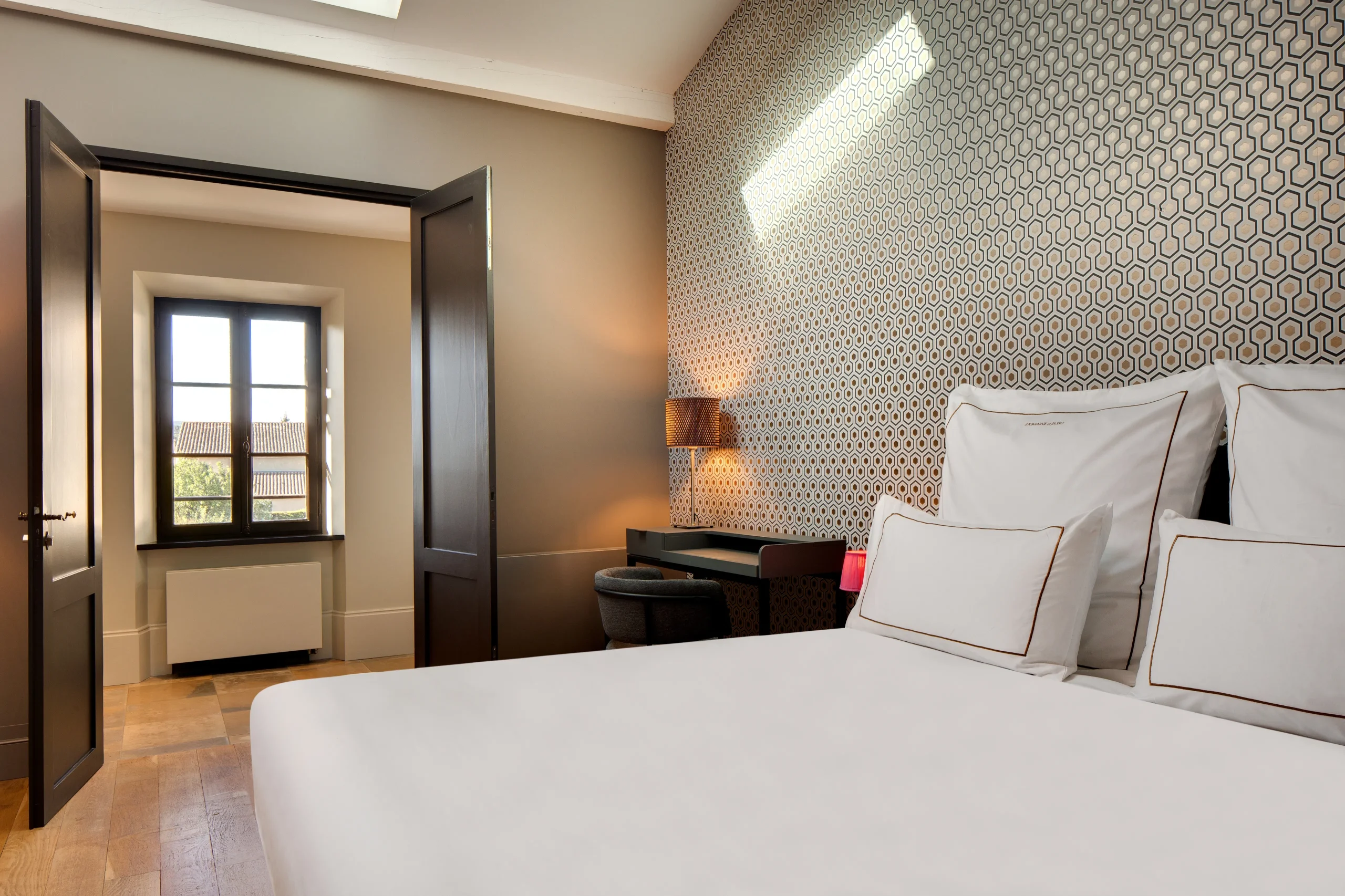 Chambre élégante avec lit et bureau moderne.